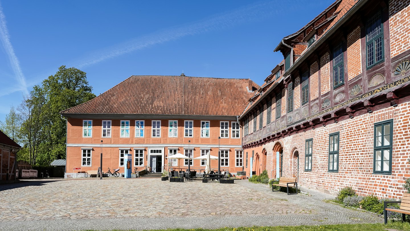 Außenterrasse mit Tischen in einem historischen europäischen Kopfsteinpflasterhof.