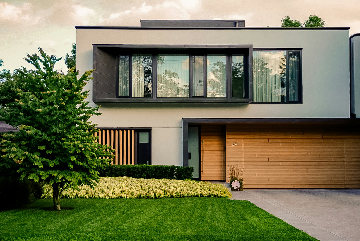 Modernes Haus mit Stuckfassade und Holztüren.