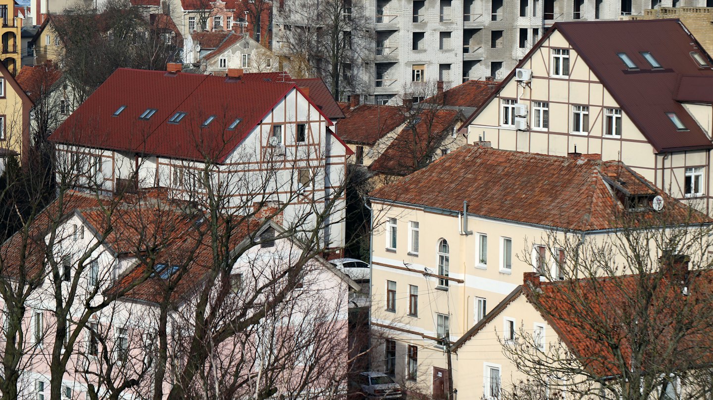 Dichtes europäisches Wohnviertel mit Ziegeldächern und einer Baustelle.